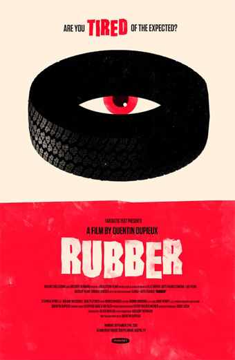 Locandina del film Rubber 2010. Un grande pneumatico nero con un occhio rosso al centro è posizionato su uno sfondo beige. In alto si legge la scritta Are you TIRED of the expected con la parola TIRED in rosso. La metà inferiore è rossa con il titolo del film RUBBER in grandi lettere bianche rovinate e i crediti sotto. Il design è surreale e inquietante, trasmette un senso di assurdità e umorismo nero.