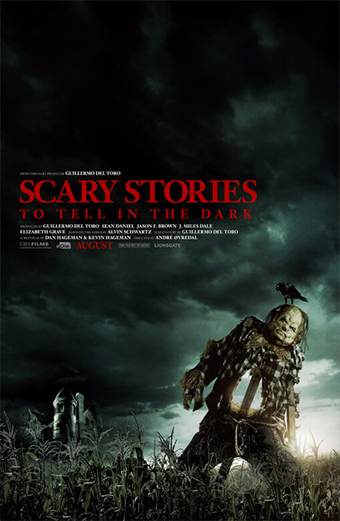 Uno spaventapasseri minaccioso si erge in un campo di mais scuro sotto un cielo tempestoso, con un corvo appollaiato sulla testa. L'atmosfera è inquietante e carica di tensione. In grande, testo rosso: SCARY STORIES TO TELL IN THE DARK. Altri testi riportano nomi di cast e produzione e una data di uscita ad agosto.