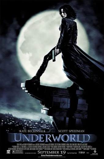 A woman in a long black coat stands on the edge of a gothic building at night holding a gun, with a large full moon illuminating a dramatic cloudy sky behind her. The cityscape below is dark and moody. The text on the poster reads Underworld, Kate Beckinsale, Scott Speedman, September 19. The overall tone is mysterious and intense.